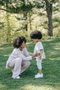 Happy mother and daughter bonding outdoors in matching outfits, showcasing love and style in a serene park.